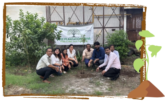 A group of volunteers posing after planting a sapling during an Atulya Foundation tree plantation drive, promoting environmental sustainability.
